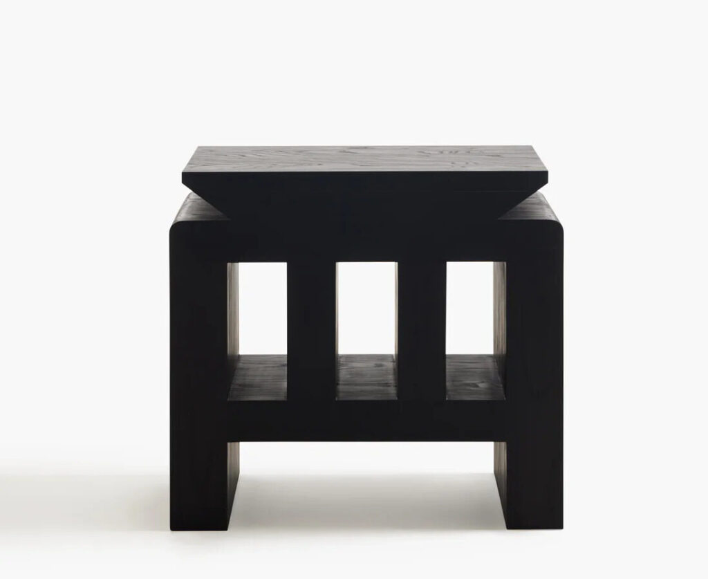 A black wooden side-table with geometric carvings