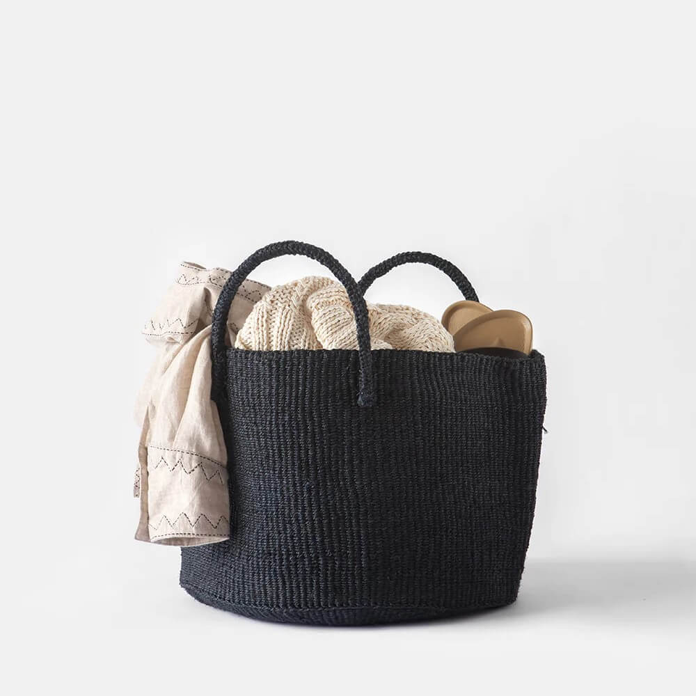 Sisal storage basket with handles in black with linen stored in it 