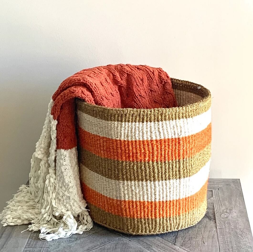 Sisal basket in a natural fiber base decorated with orange and white stripes