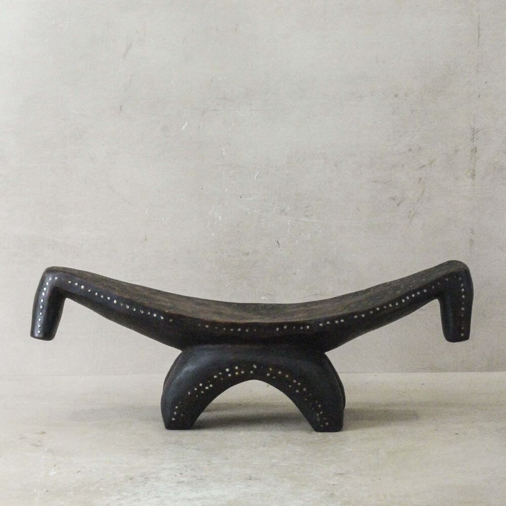 Gifts for Interior Design lovers - A wooden tradtional headrest from Congo, shaped like a low stool, embellished with metal pins