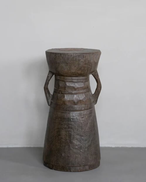 A dark-brown stool and mortar in the shape of a traditional African drum