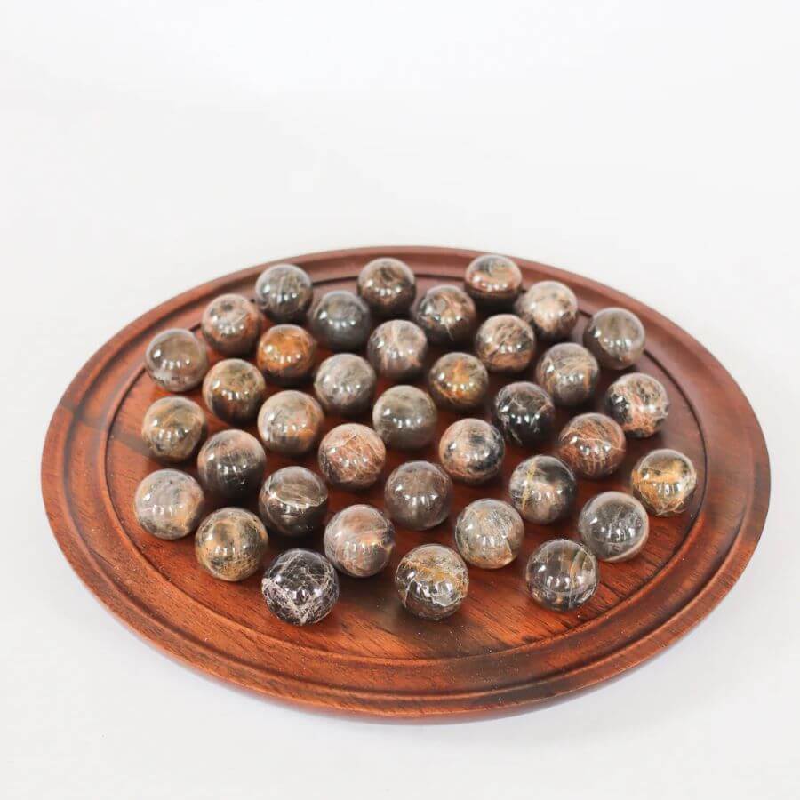 Ancient solitaire game from Madagascar made from a circular sandalwood board and semi precious moonstone spheres