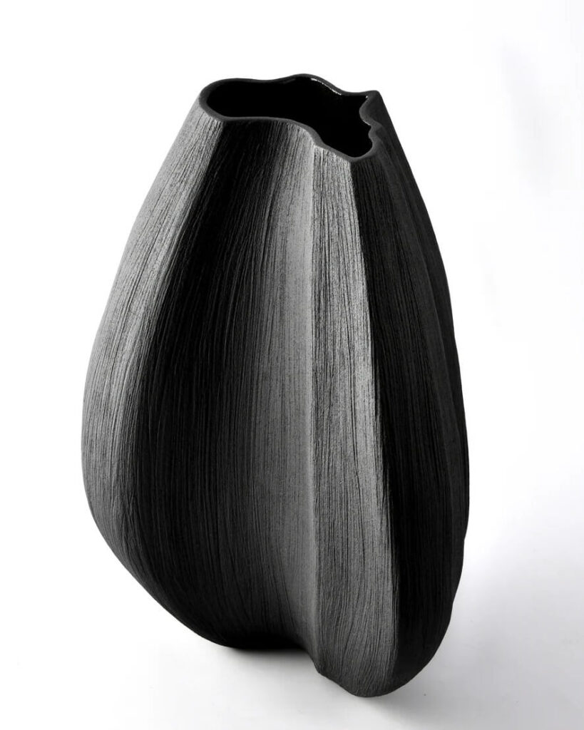 A black ceramic vase made from a variety of clays and glazes inspired by the shape of the African continent