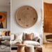 A minimalist living room triptych features gorgeous African wall decor. Left: abstract African paintings above a white sofa; Center: woven basket wall art; Right: leather chair in front of a patterned mud cloth wall hanging.