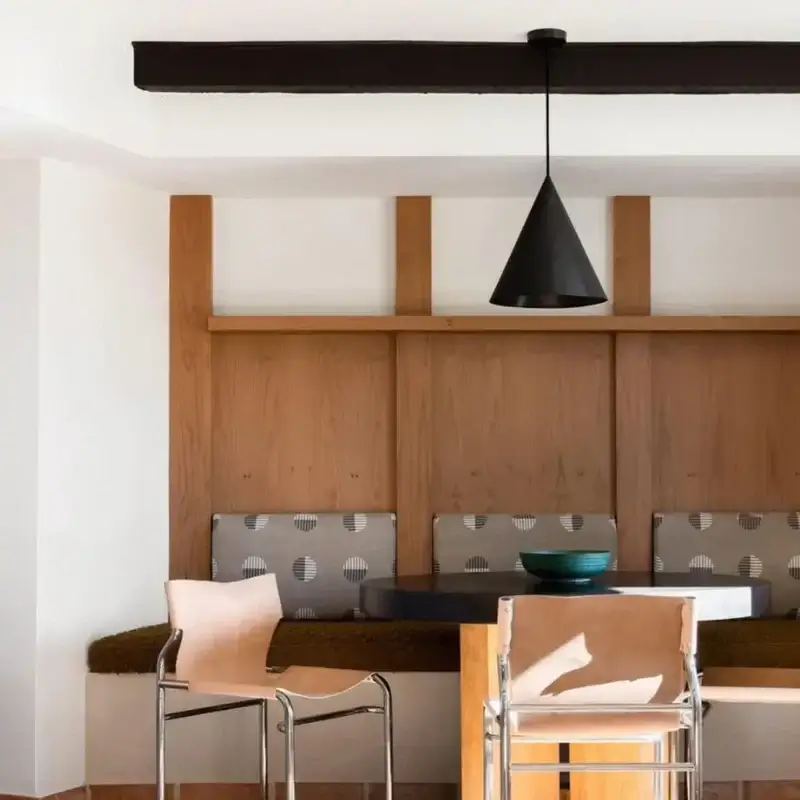 Cone-shaped black brass lamp in a casual dining area