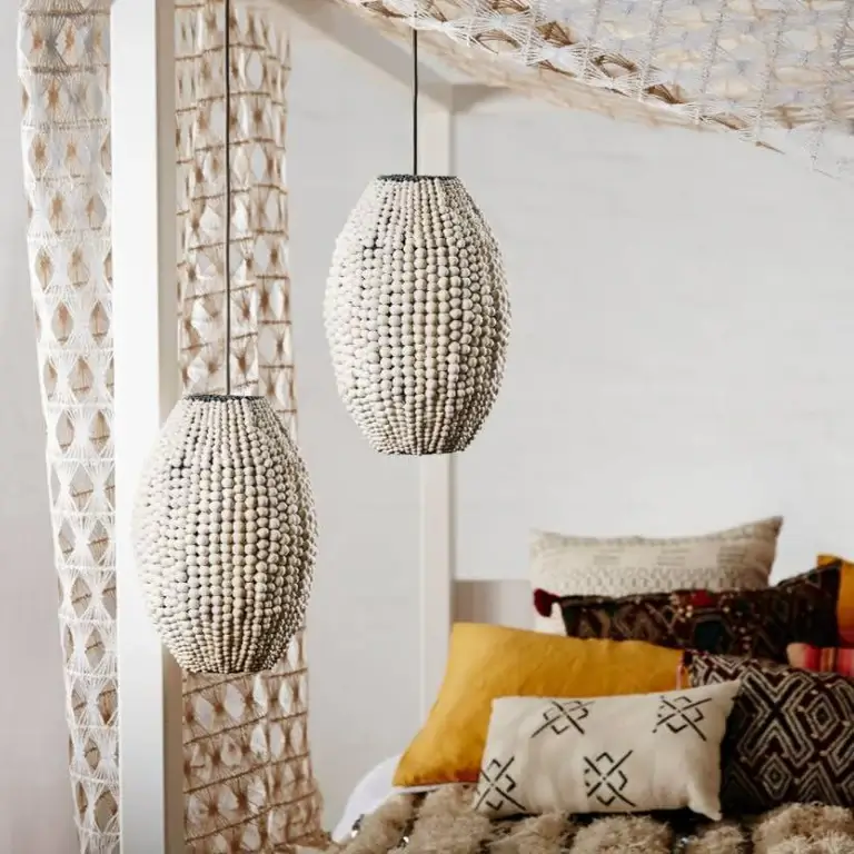 Two oval shaped pendant lamps handmade with off white clay beads in a boho interior