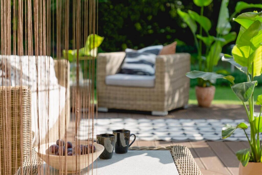 Blurry picture of a sunny outdoor terrace with beautiful box style chairs with plants