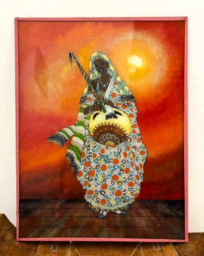 Senegalese reverse glass painting of a woman griot dressed in flowy traditional clothes and playing the kora over a bright orange and red background