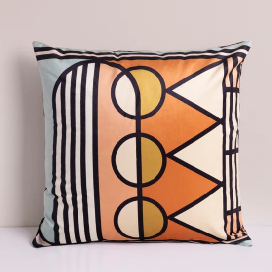 Colorful velvet pillow with a mix of different shades including blue, orange, yellow and pink. It had abstract geometric patterns