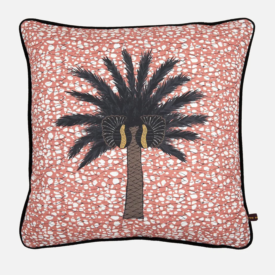 Colorful pink throw pillow with a palm tree print in the middle