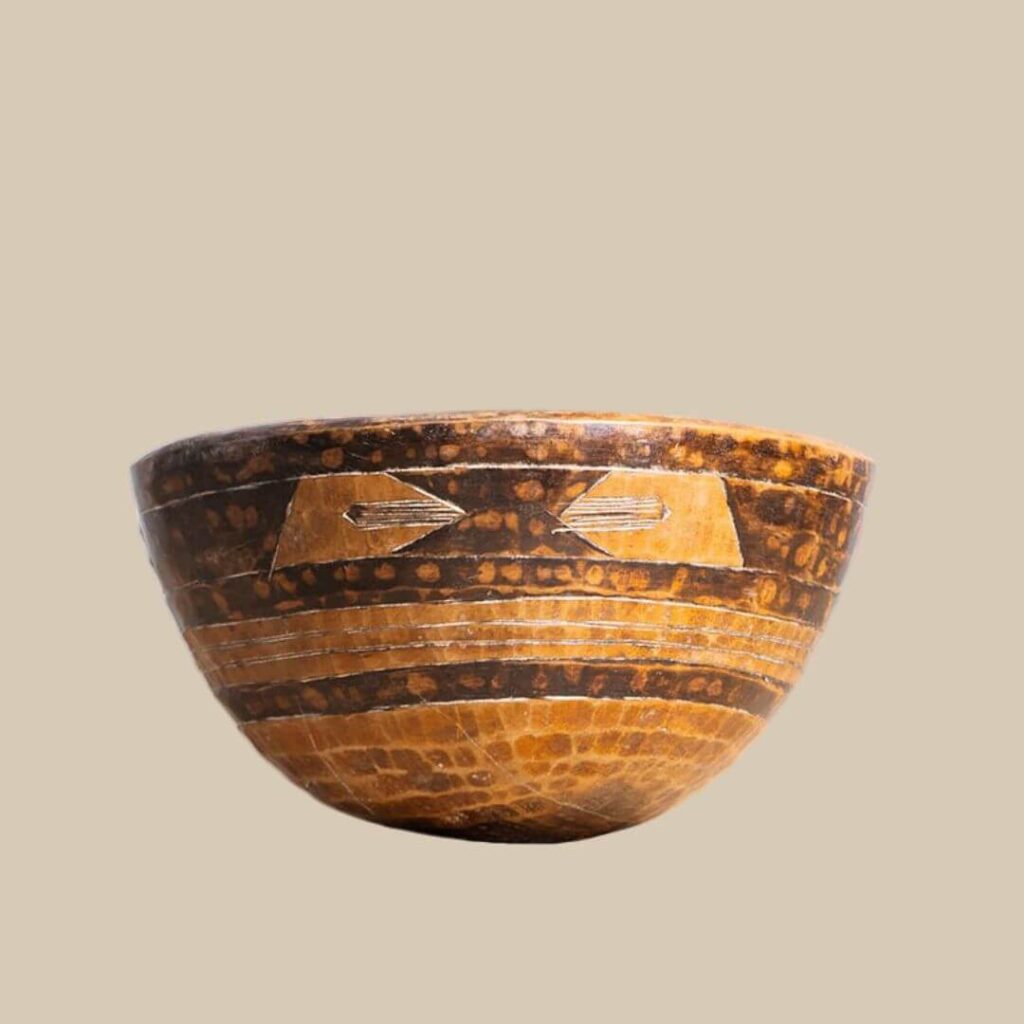 Close up of a beautiful, hand-crafted African bowl with brown and tan geometric designs.