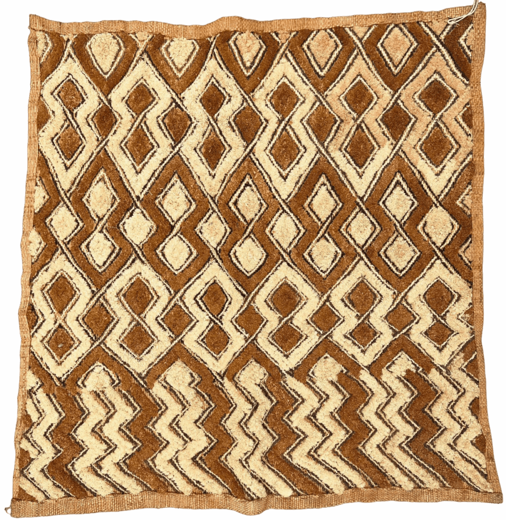Close-up of a Kuba cloth with geometric patterns in brown and beige.