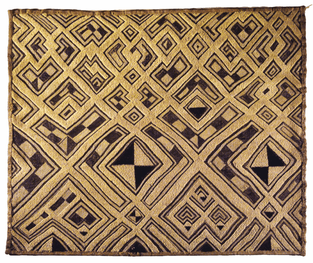 A square piece of Kuba cloth displaying an elaborate geometric pattern in brown and tan. The cloth is woven with repeating motifs of diamonds and squares, some filled with solid brown or divided into checkered or quartered patterns. The craftsmanship highlights the symmetrical complexity of the design.