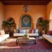 Elegant display of Moroccan interior design with white sofas, patterned pillows, and a central Persian rug, all set against warm, terracotta walls and archways.