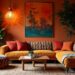 Cozy creative interior: living room with orange walls and a large L-shaped sofa accented by patterned cushions. A vibrant landscape painting and lush plants enhance warmth.