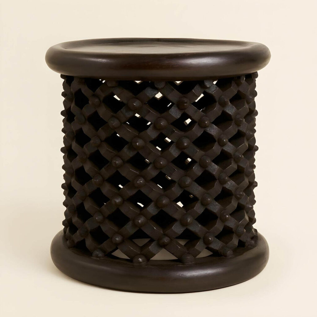 Dark-wood Bamileke stool, one of the most popular African stools, on a light studio background