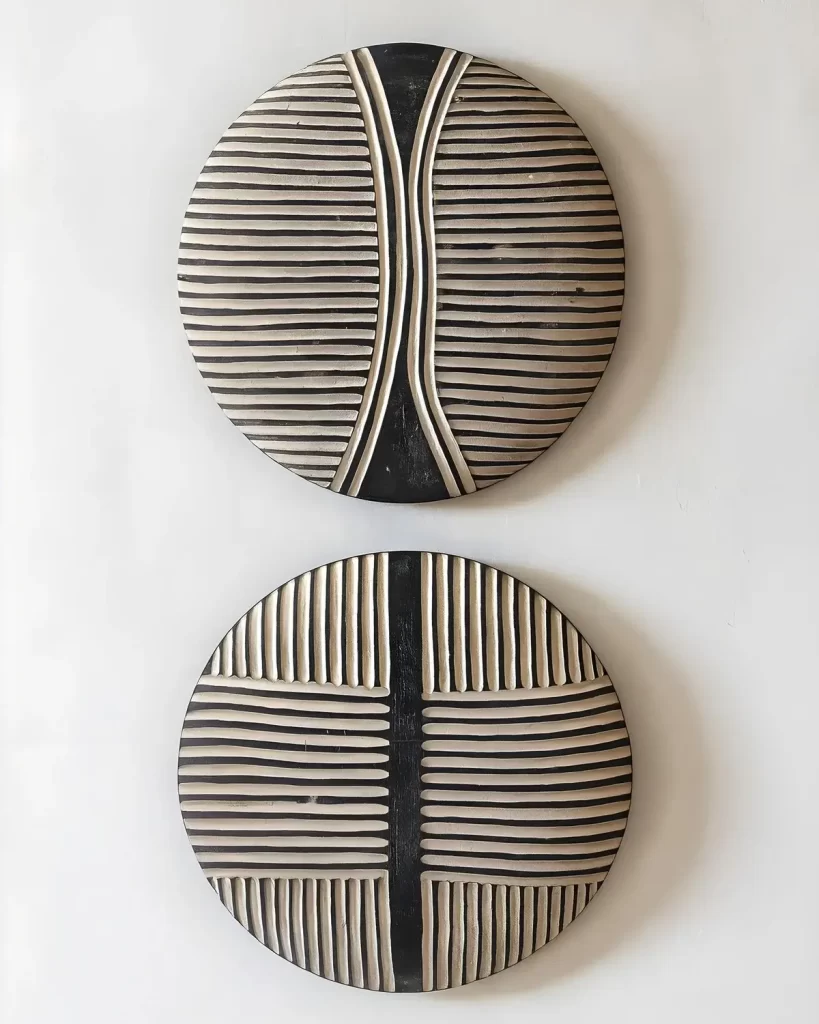Two wooden Tikar shields from Cameroon made in Dark wood with white geometric lines. Stunning home decor showpieces.
