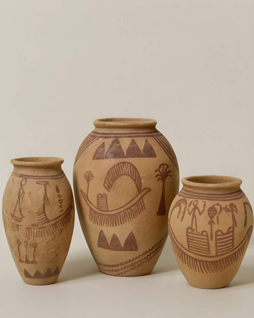 Ancient Egyptian pottery: Three beige clay pots with primitive brown designs depicting figures, plants, and abstract patterns. The tone is earthy and culturally rich.