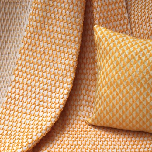 Yellow throw pillow on a yellow throw blanket