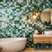A split-screen showcase of modern Moroccan tiles for bathroom featuring terracotta Bejmat floors on one side and vibrant teal Zellige wall tiles on the other.