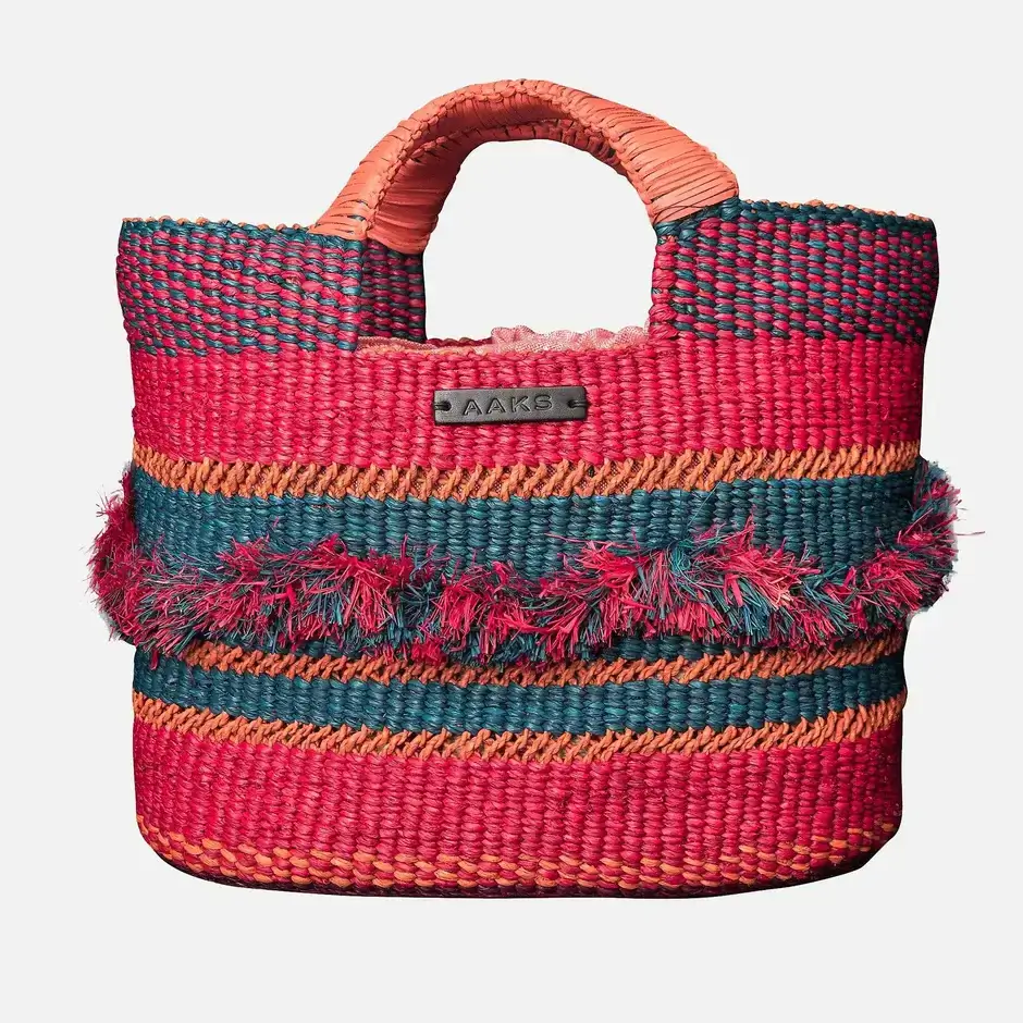 A colorful woven tote bag with red, orange, and teal horizontal stripes, featuring short handles and textured fringe detailing across the middle.